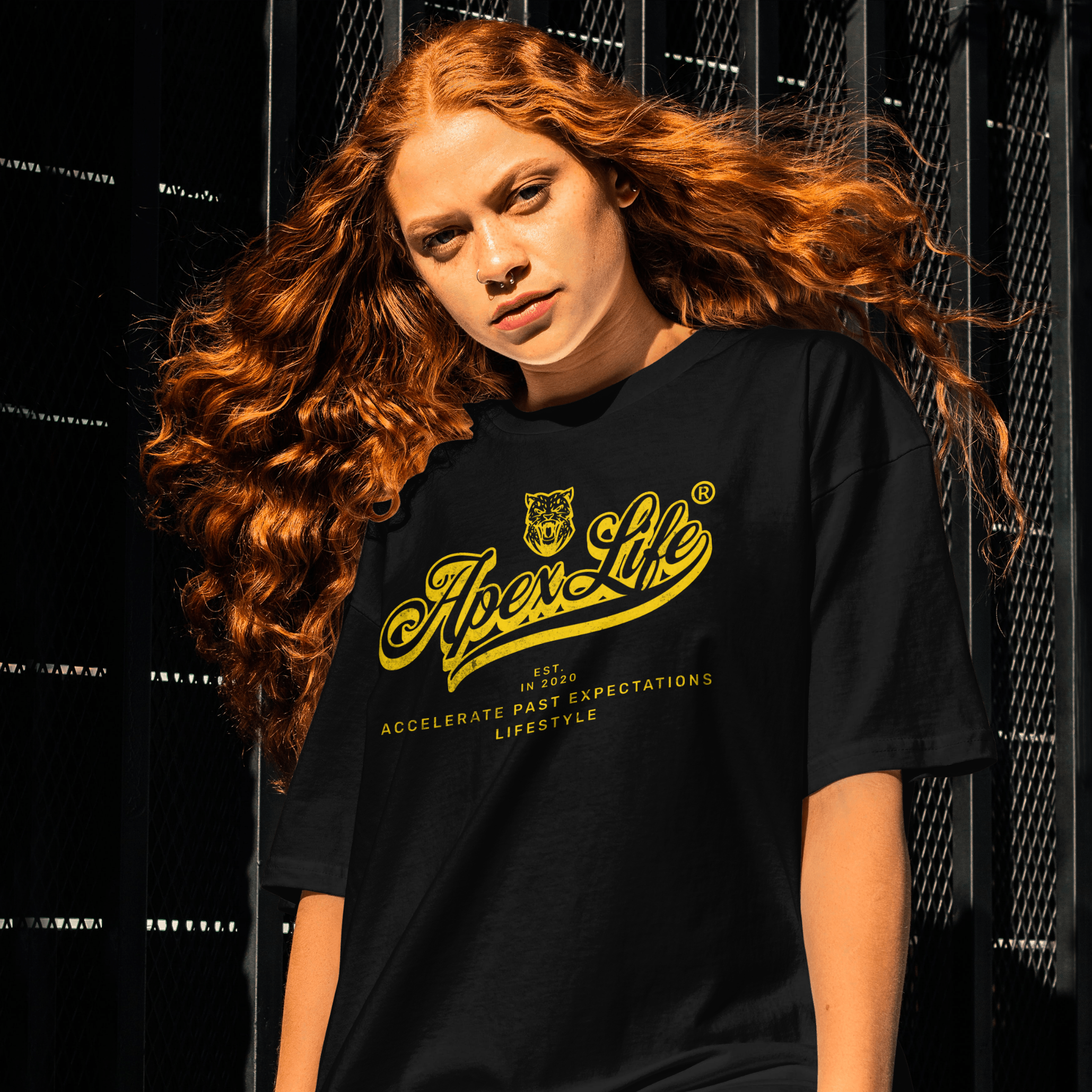 Person wearing a black t-shirt with yellow text and logo against a dark background